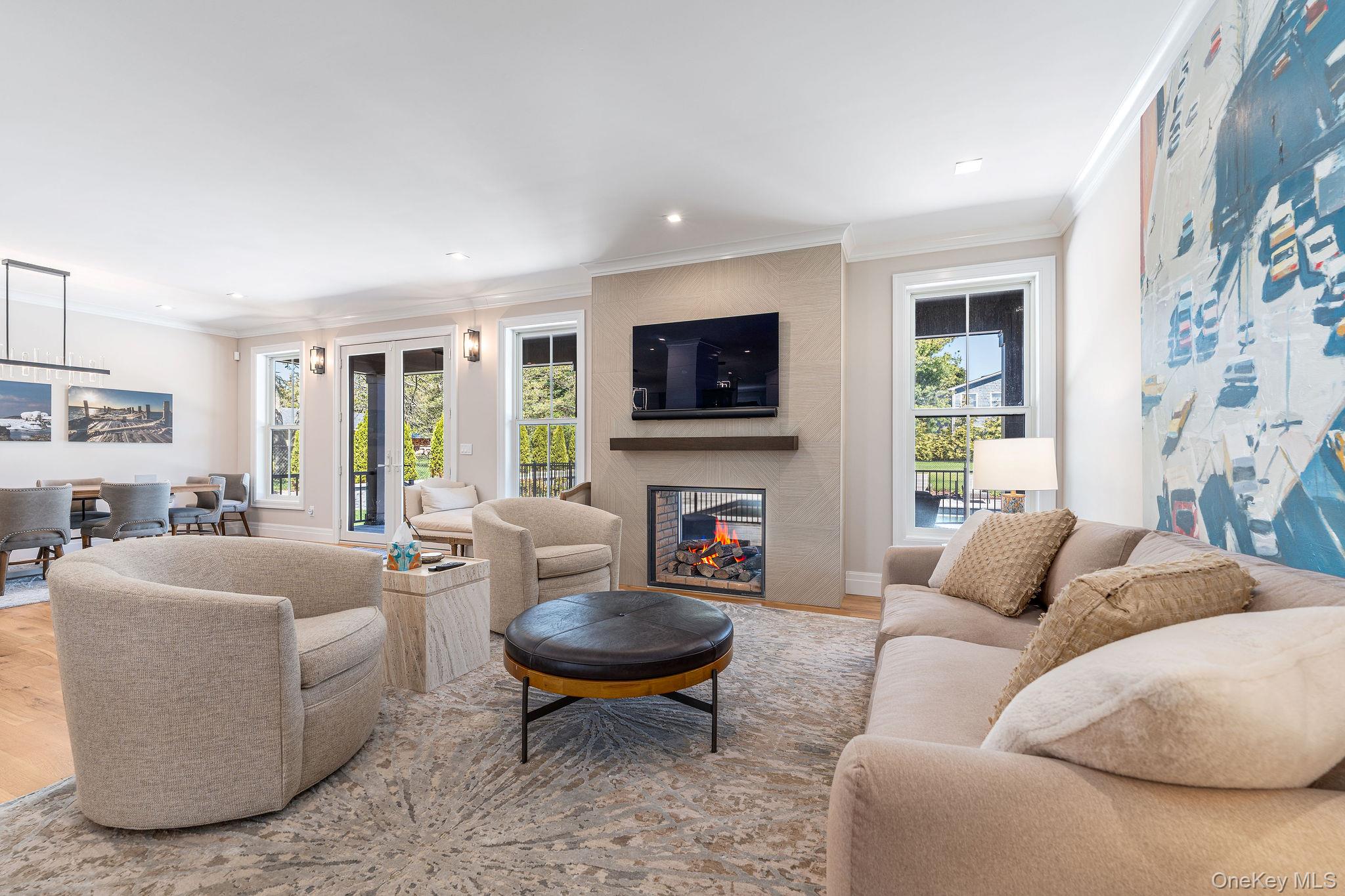 1665 Glenn Road Southold, NY 11971 - Photo 16 of 46 a living room with furniture a fireplace a flat screen tv and windows