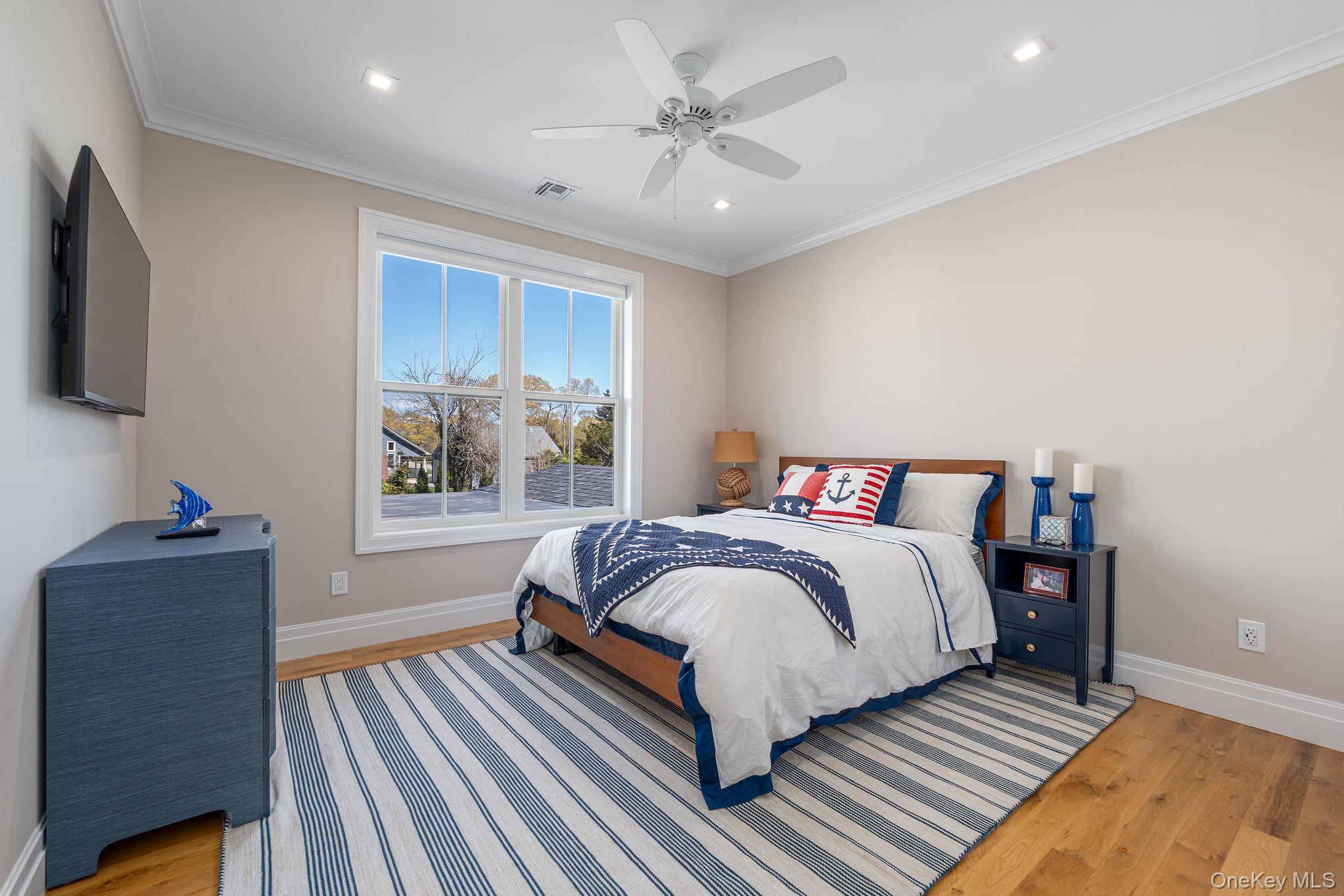 1665 Glenn Road Southold, NY 11971 - Photo 29 of 46 a bedroom with bed and a chandelier