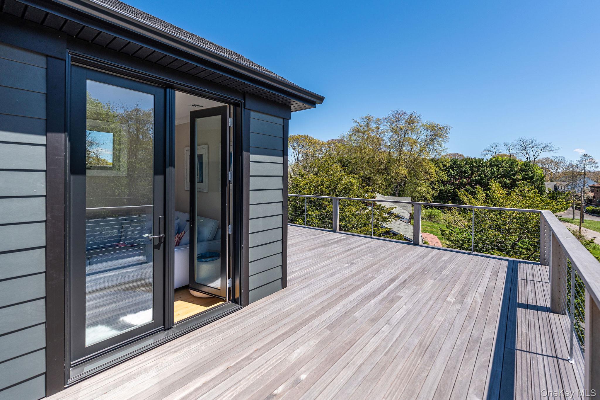 1665 Glenn Road Southold, NY 11971 - Photo 40 of 46 a view of a balcony with wooden floor and iron stairs