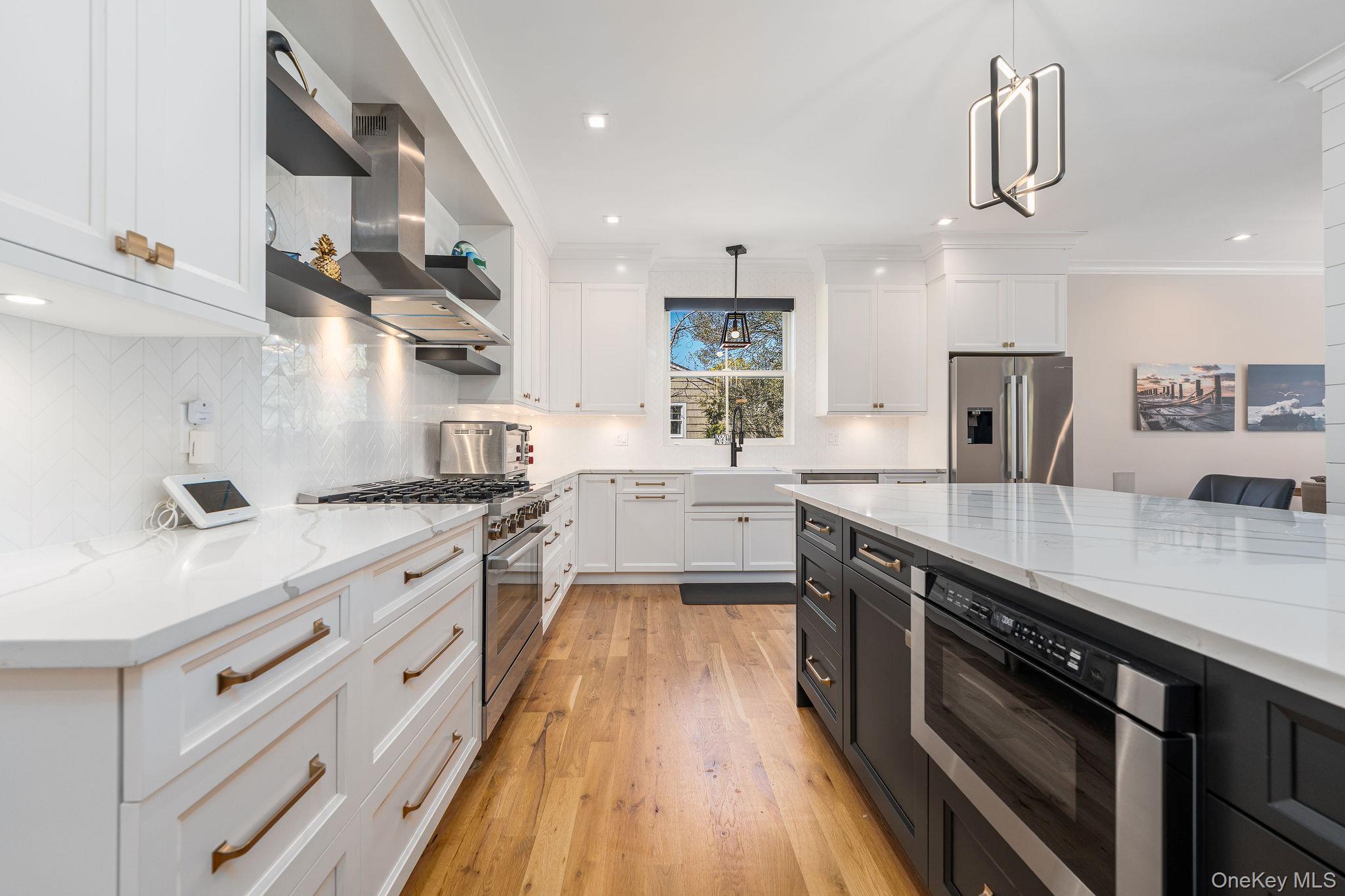 1665 Glenn Road Southold, NY 11971 - Photo 9 of 46 a kitchen with stainless steel appliances granite countertop a sink a stove and a wooden floors
