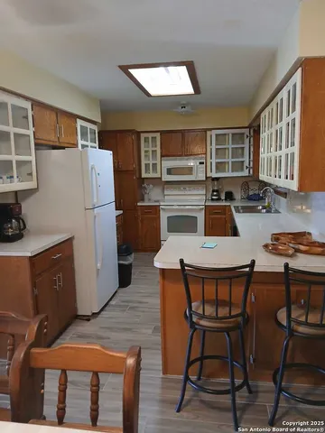 a kitchen with a table chairs refrigerator and microwave