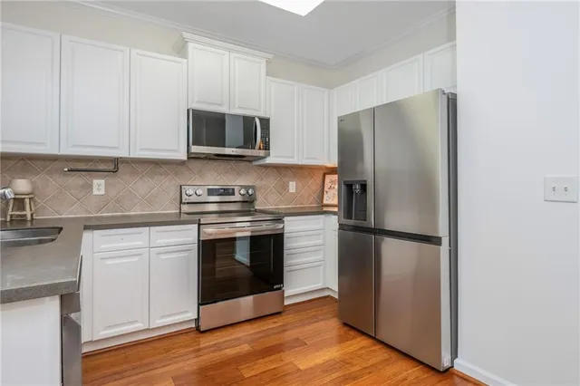 a kitchen with stainless steel appliances a refrigerator stove and microwave
