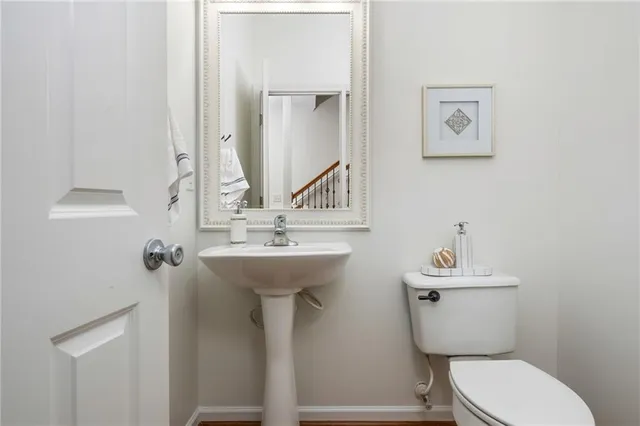 a bathroom with a toilet sink and mirror