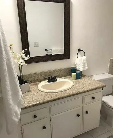 a bathroom with a granite countertop sink and a mirror