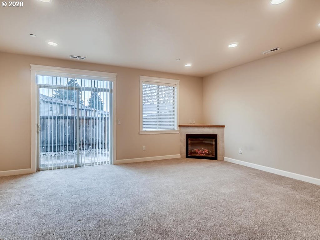 241 North 33rd Court Ridgefield, WA 98642 - Photo 4 of 12 an empty room with floor to ceiling window and fireplace