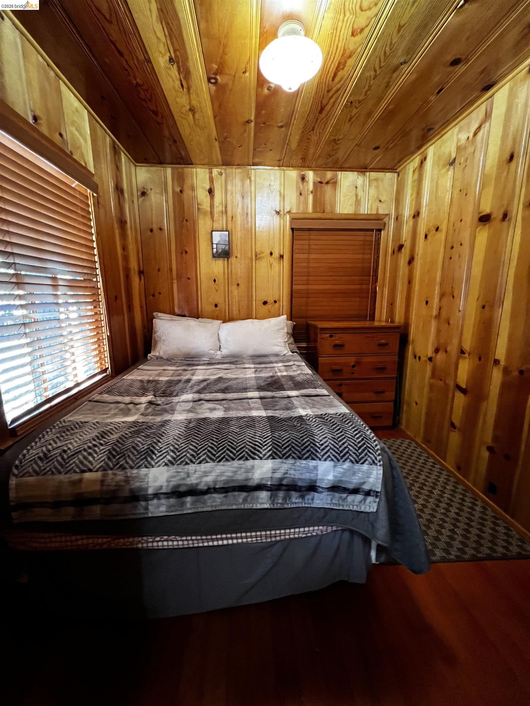 39 Cow Creek Road Pinecrest, CA 95364 - Photo 34 of 44 a bedroom with a bed and wooden floor