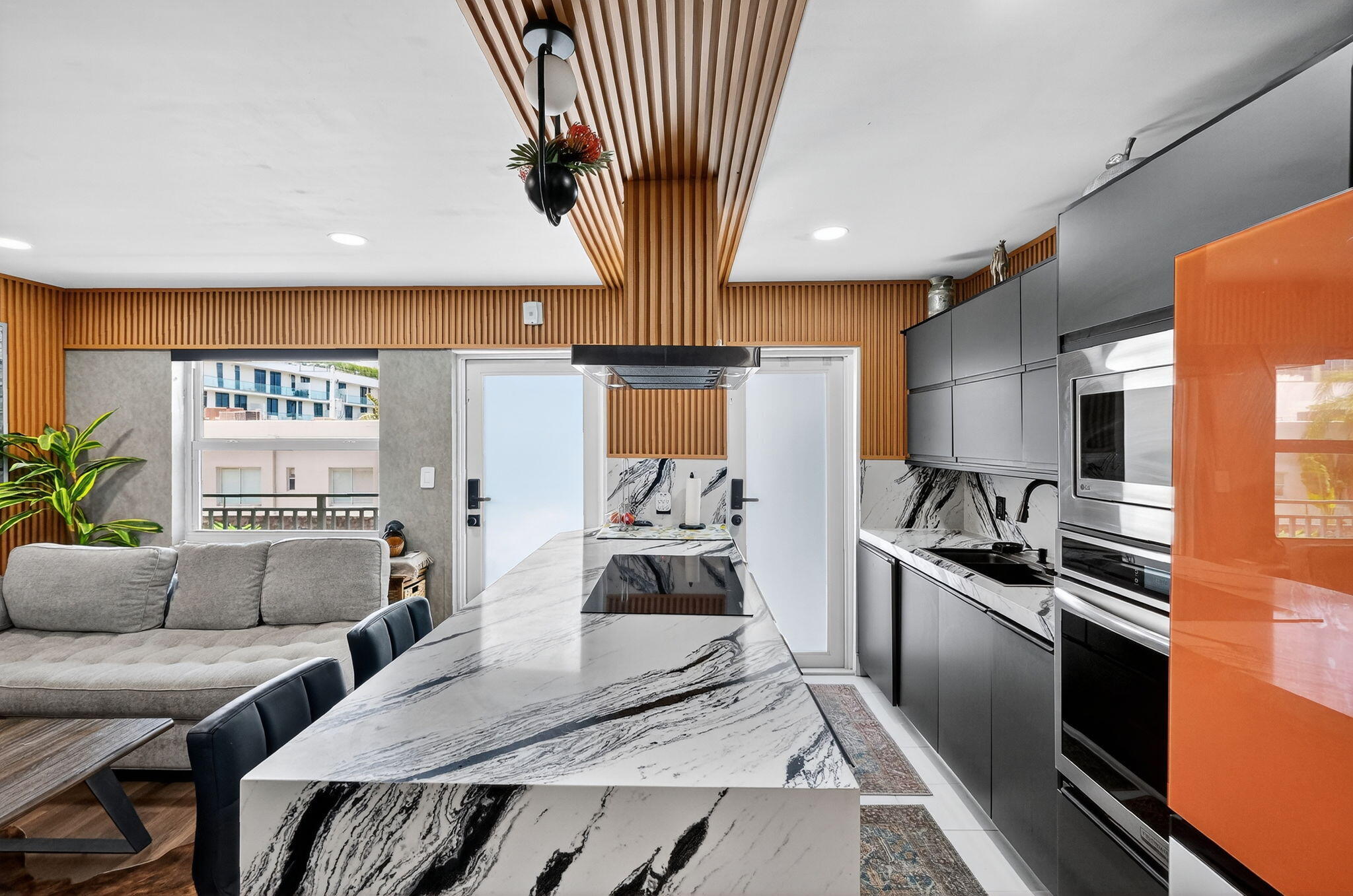 363 Washington Avenue, Unit 32 Miami Beach, FL 33139 - Photo 12 of 32 a kitchen with stainless steel appliances granite countertop a refrigerator a sink dishwasher a stove and a dining table with wooden floor