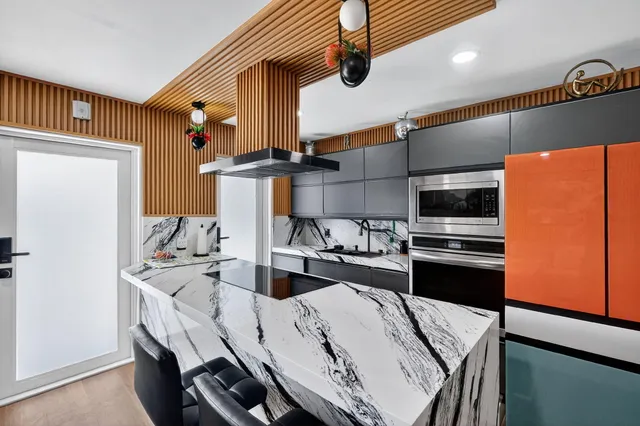 a kitchen with stainless steel appliances kitchen island a stove a table and chairs