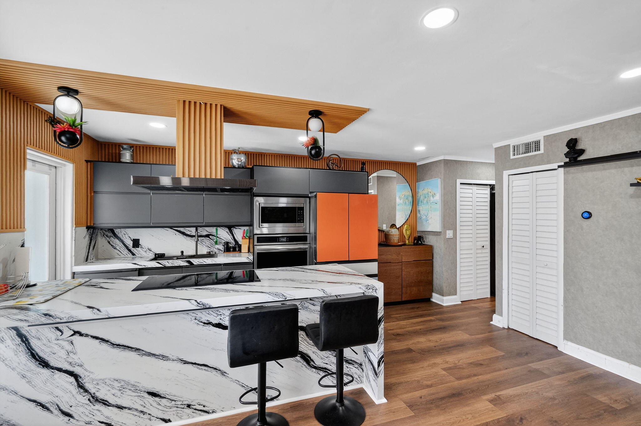 363 Washington Avenue, Unit 32 Miami Beach, FL 33139 - Photo 10 of 32 a kitchen with stainless steel appliances kitchen island granite countertop a table chairs in it and wooden floors