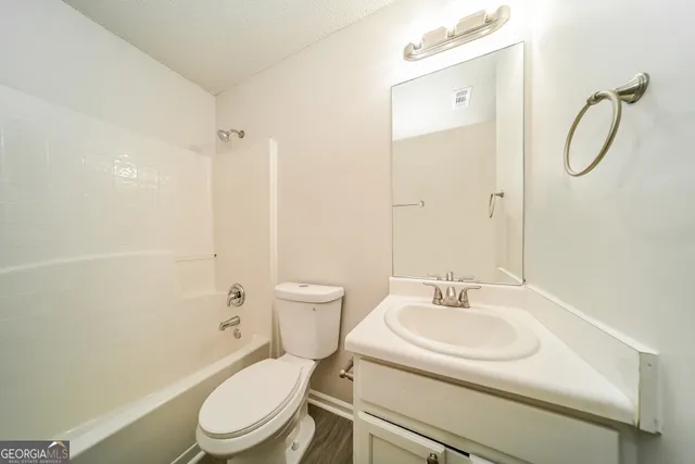 a white toilet sitting next to a bathroom sink