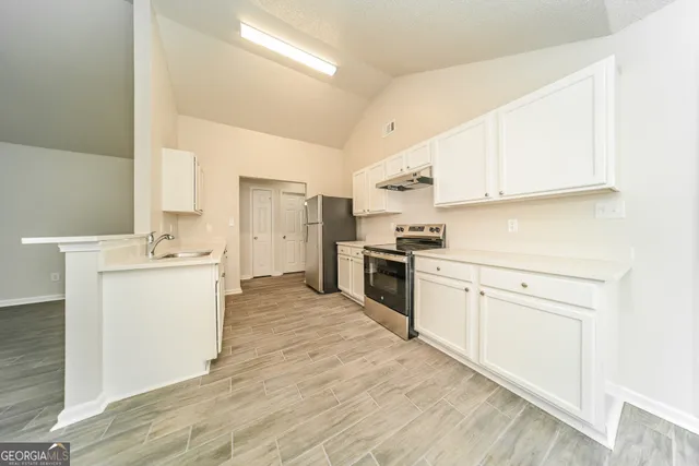 a kitchen with white cabinets and white appliances