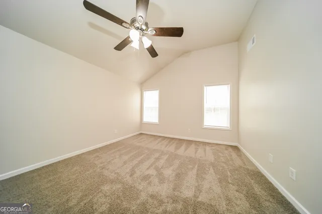 an empty room with windows and fan