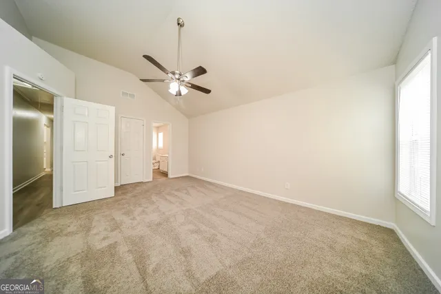 an empty room with fan and windows