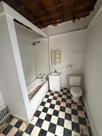 a bathroom with a black and white checkered floor