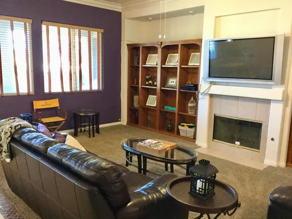 a living room with furniture a fireplace and a flat screen tv