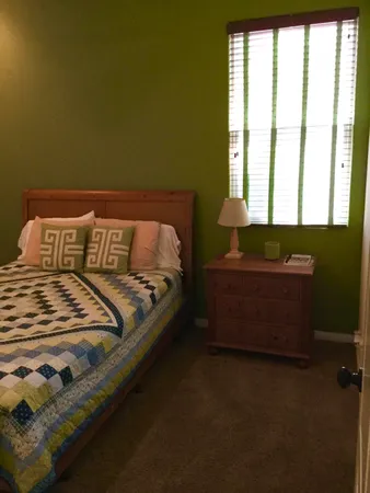 a bed sitting in a bedroom next to a window