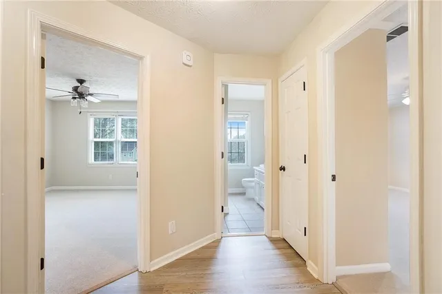 a view of a bathroom with a glass door shower a sink and a wooden floor
