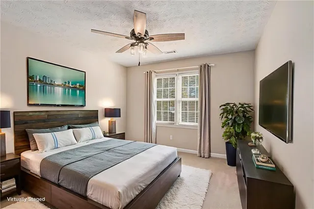 a bedroom with a bed table and a flat screen tv