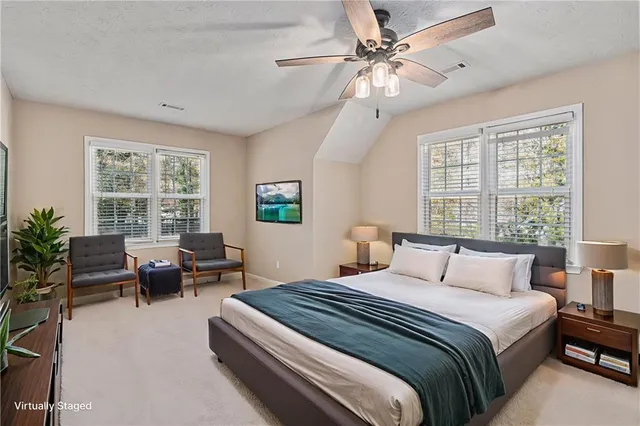 a bedroom with a large bed and windows