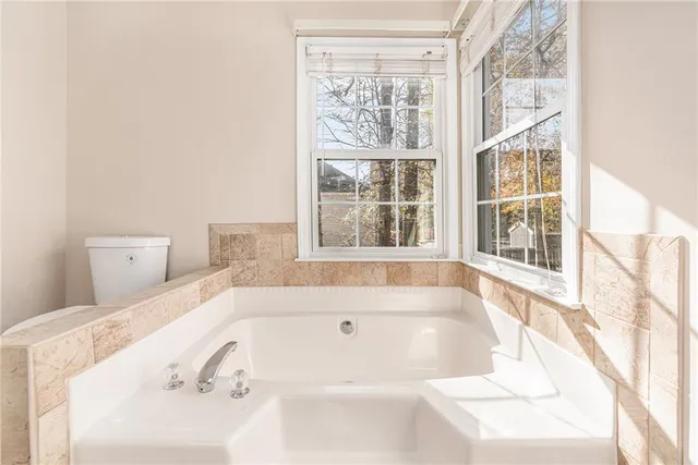 a bathroom with bathtub and window