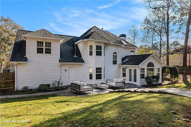 a front view of house with yard and trees in the background