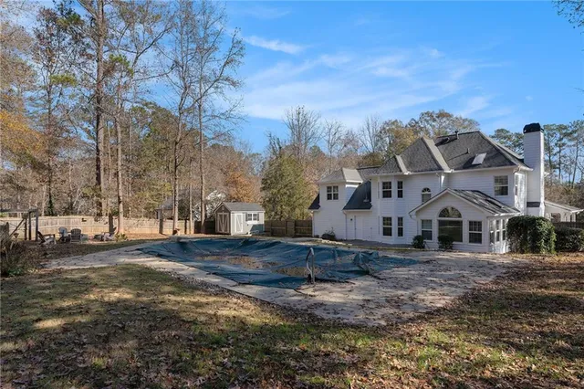 a view of a large white house with a yard covered with snow