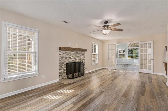 a view of empty room with a fireplace and wooden floor