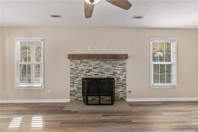 a living room with a fireplace and wooden floor