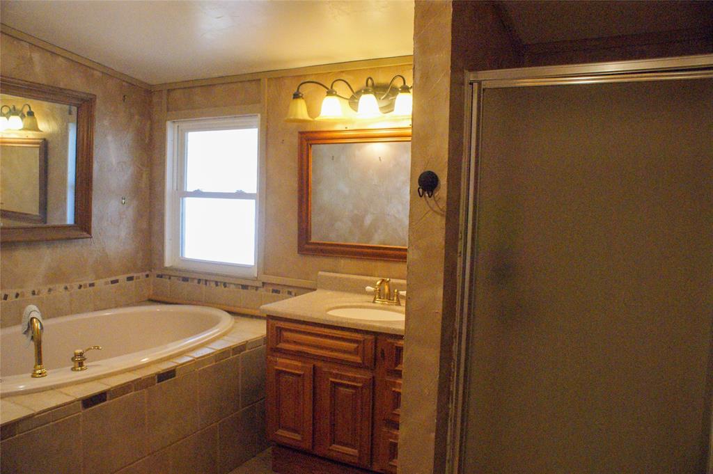 7424 North Locust Street Denton, TX 76207 - Photo 4 of 9 a bathroom with a granite countertop sink and a mirror