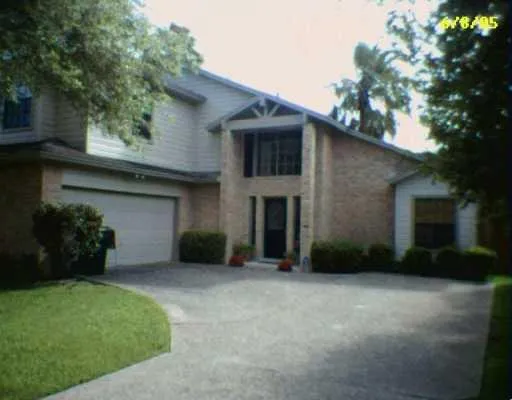 a view of a house with a yard and a large tree