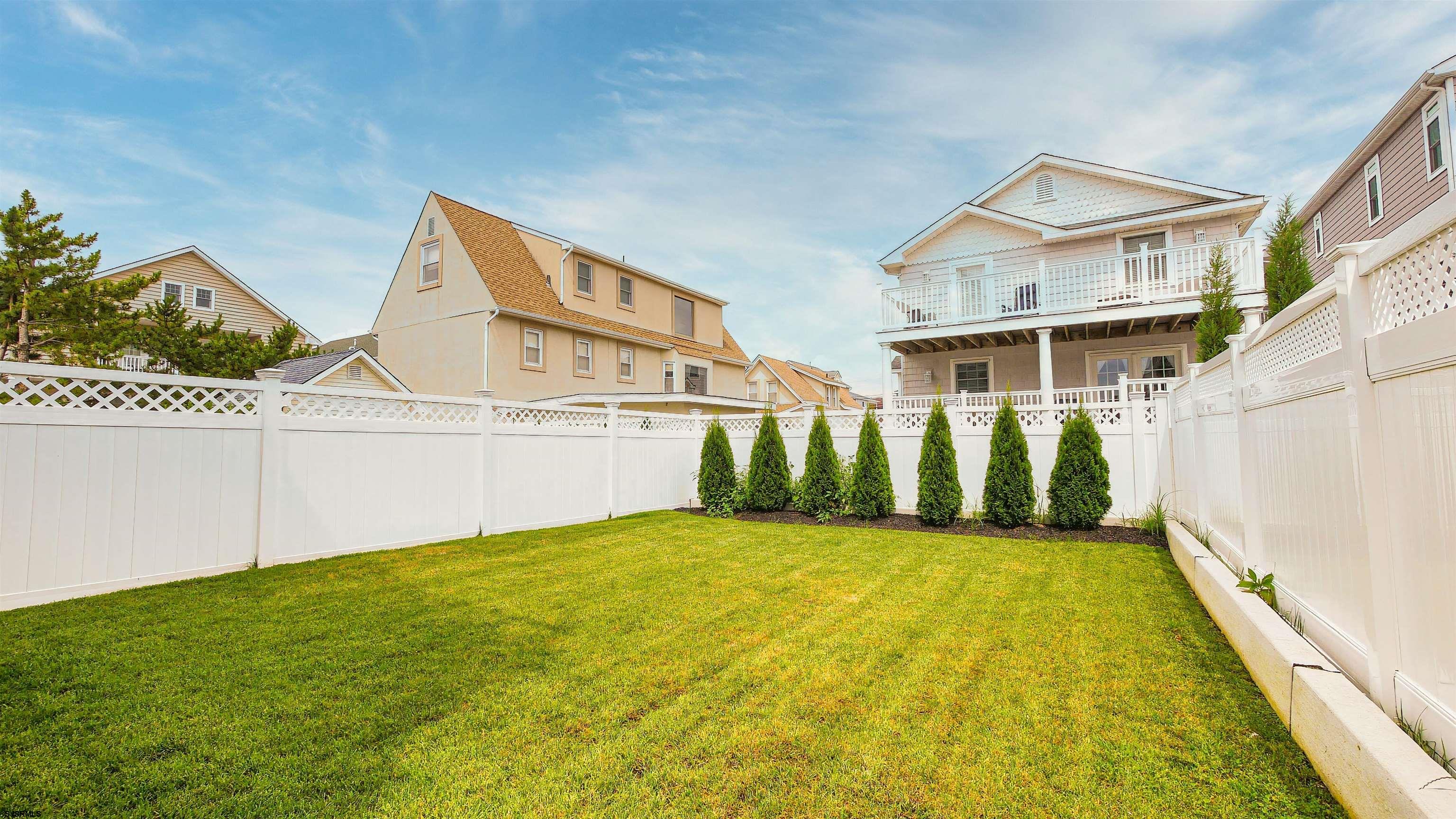 15 North Jefferson Avenue, Unit B Margate City, NJ 08402 - Photo 13 of 13 a view of a white house next to a yard with potted plants