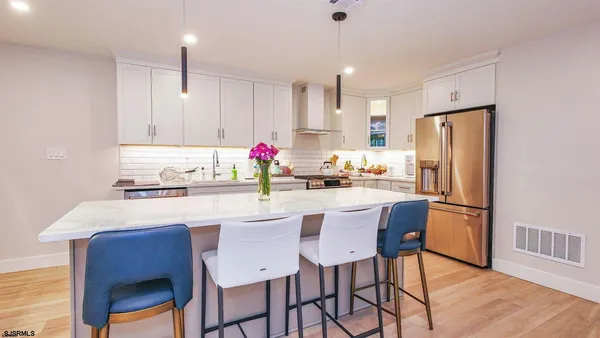 a kitchen with refrigerator cabinets dining table and chairs