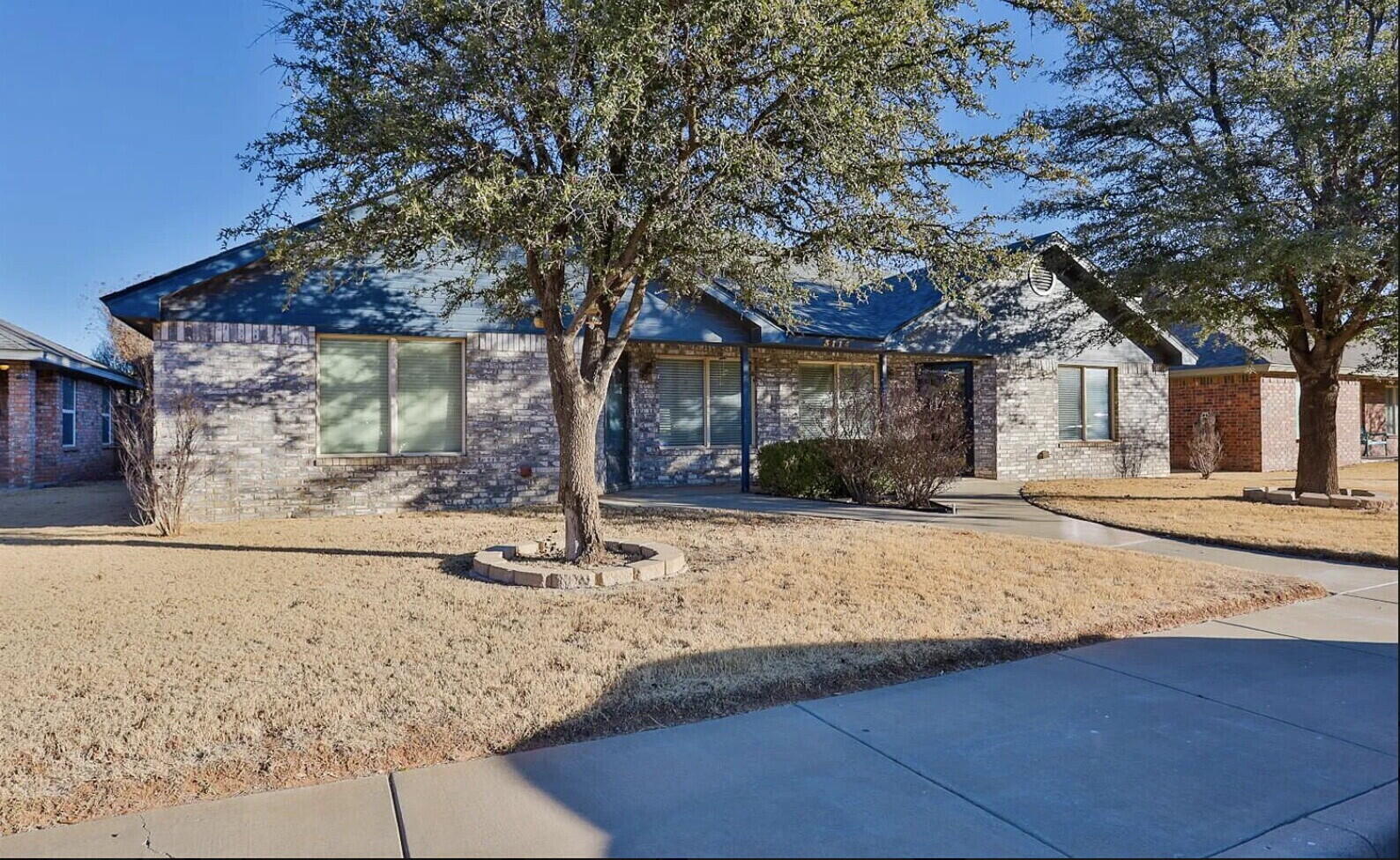 3114 111th Street Lubbock, TX 79423 - Photo 1 of 26 a front view of a house with a yard covered with snow