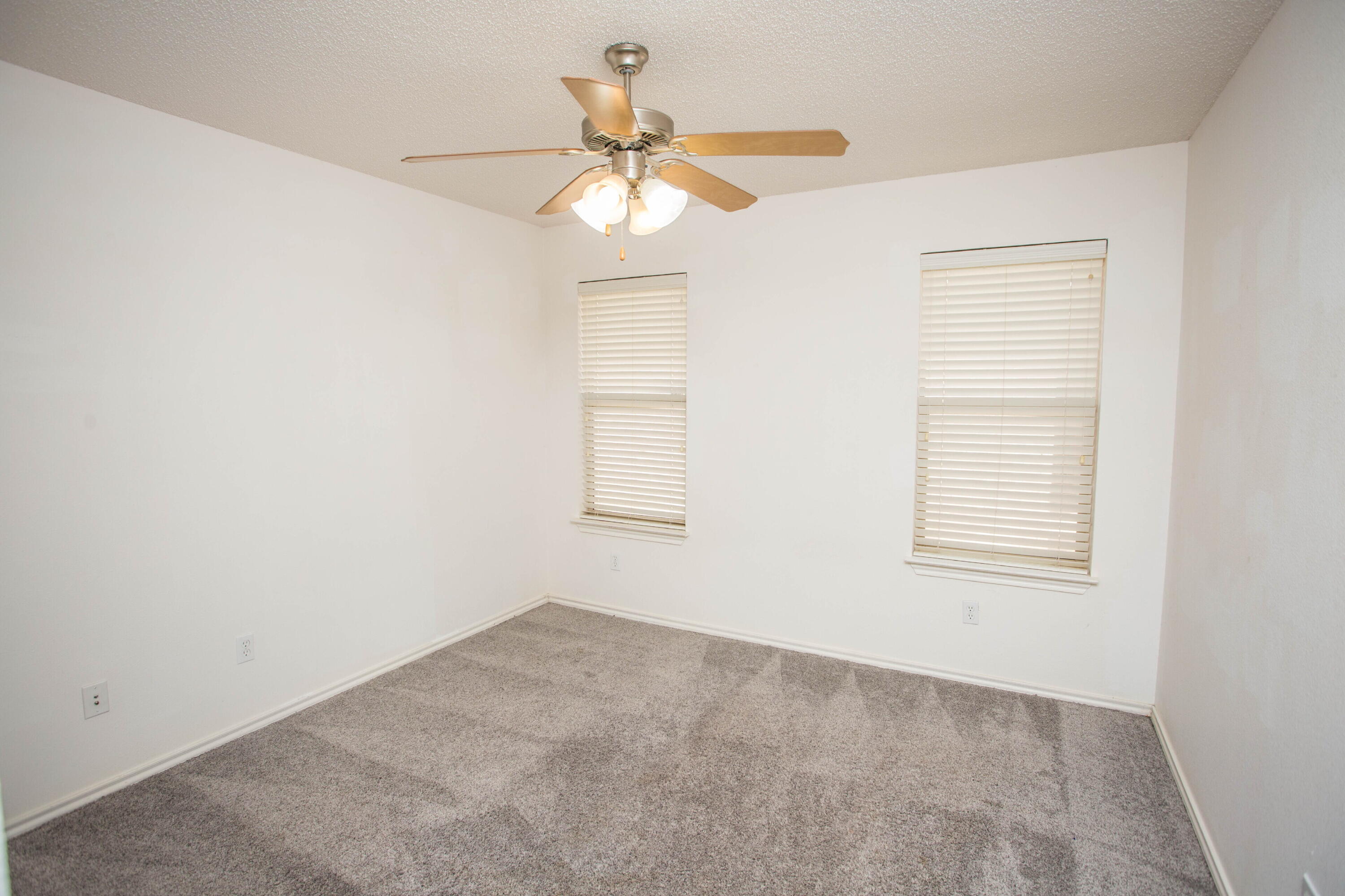 3114 111th Street Lubbock, TX 79423 - Photo 19 of 26 an empty room with a window and a fan