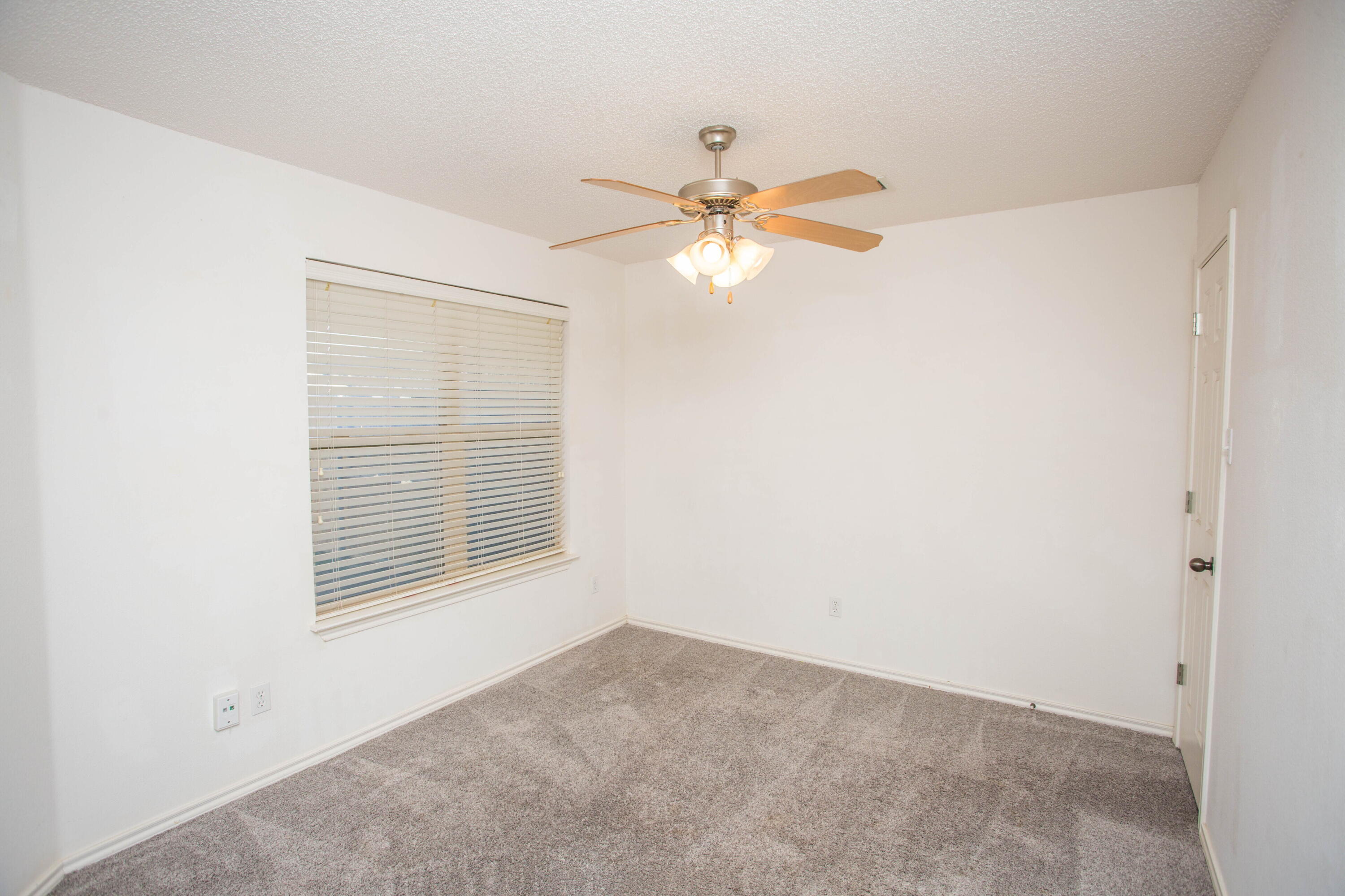 3114 111th Street Lubbock, TX 79423 - Photo 22 of 26 an empty room with a window and a fan