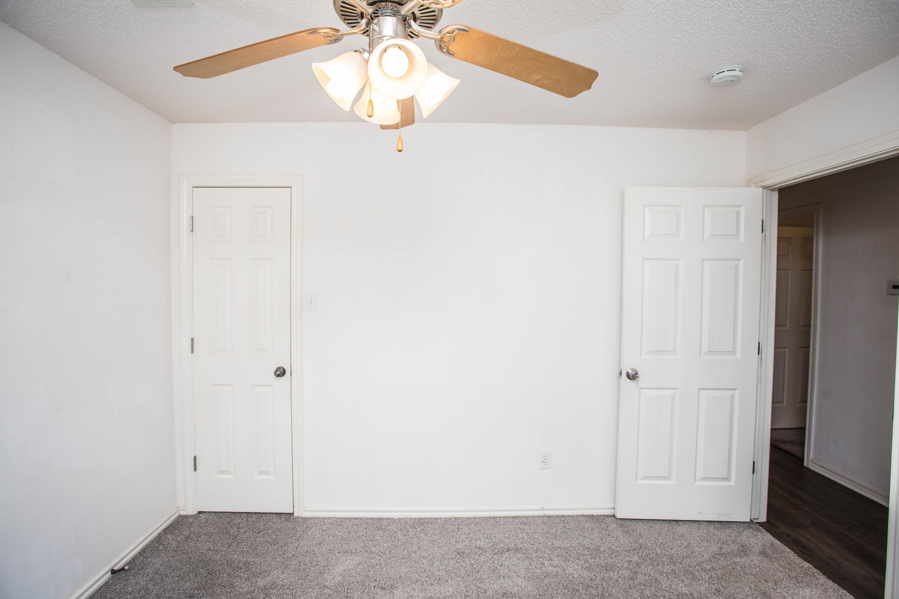3114 111th Street Lubbock, TX 79423 - Photo 23 of 26 an empty room with a chandelier fan and a window