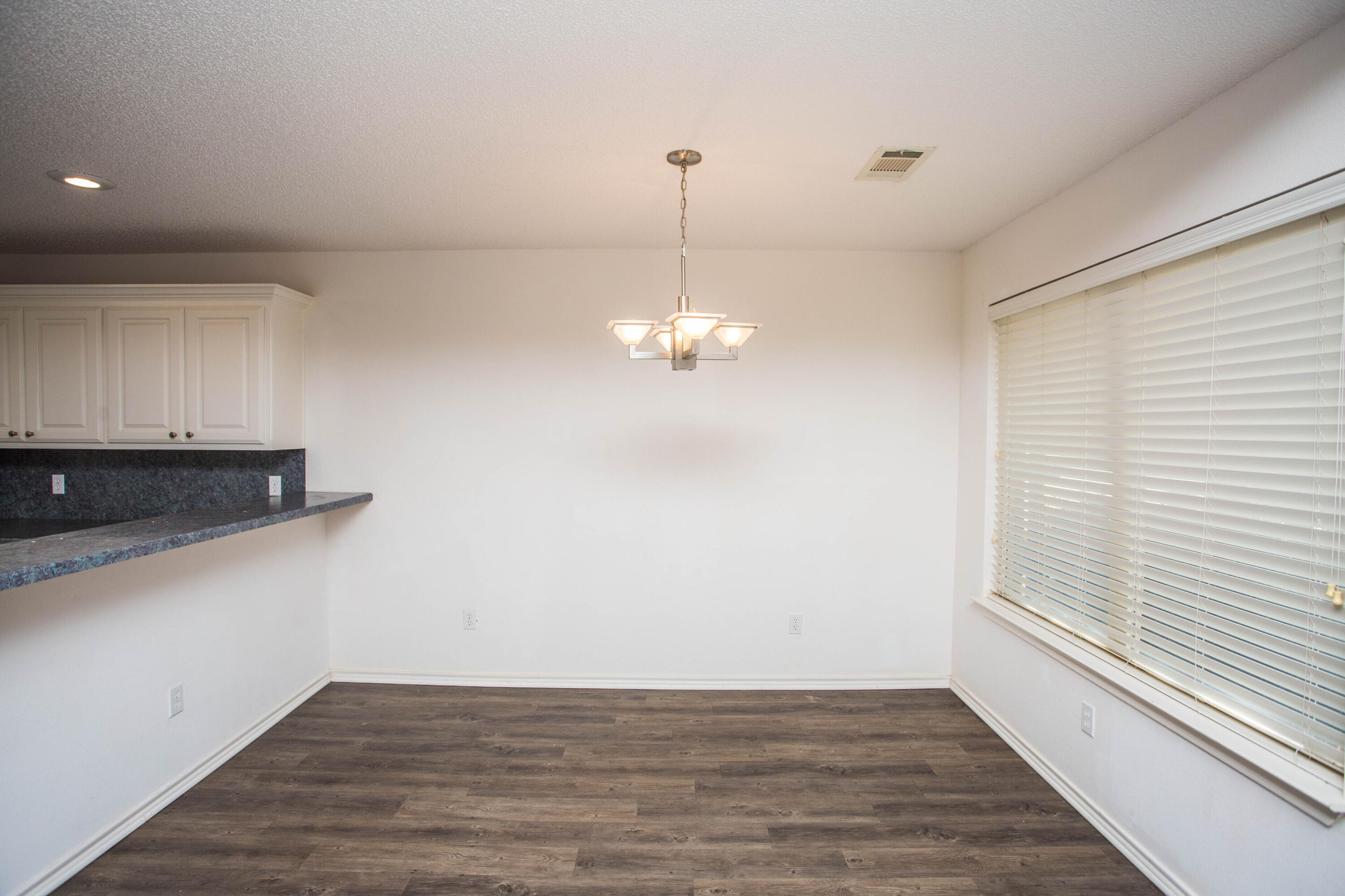3114 111th Street Lubbock, TX 79423 - Photo 7 of 26 a view of a chandelier fan and wooden floor