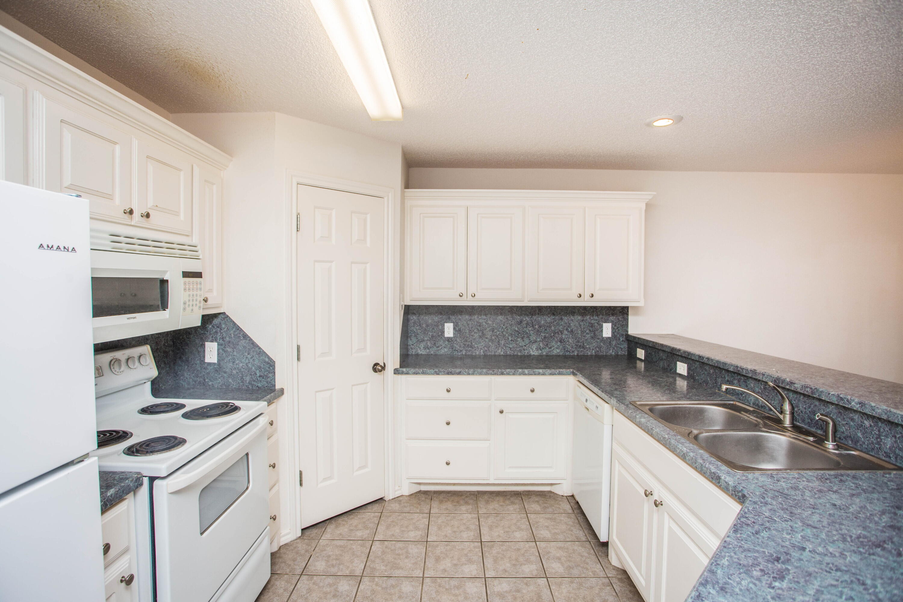 3114 111th Street Lubbock, TX 79423 - Photo 9 of 26 a kitchen with granite countertop a sink a stove and cabinets