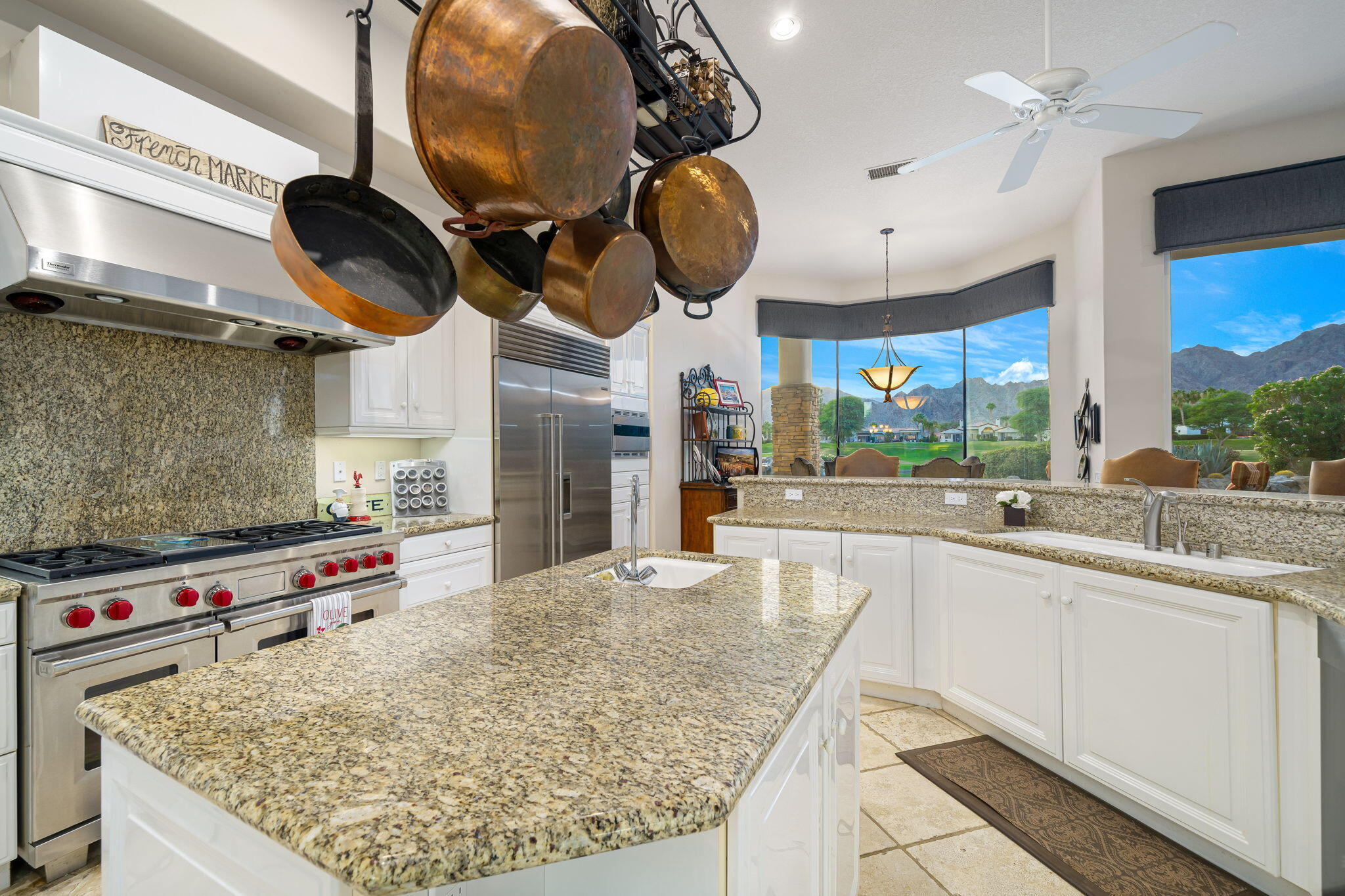 80218 Hermitage La Quinta, CA 92253 - Photo 50 of 92 a kitchen with kitchen island granite countertop a stove and a sink