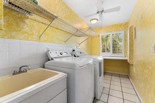 a living room with couches floor to ceiling window dining table and chairs
