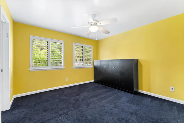 a view of a house with a big yard and palm trees