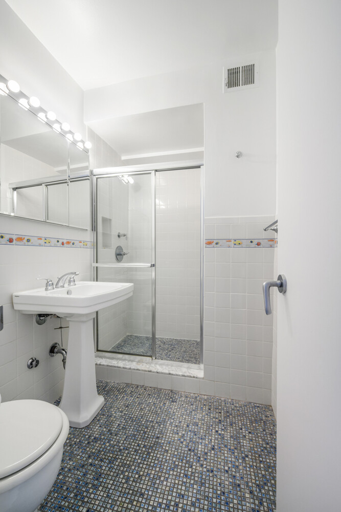 207 East 74th Street, Unit 5JH Manhattan, NY 10021 - Photo 12 of 21 a bathroom with a sink toilet and shower