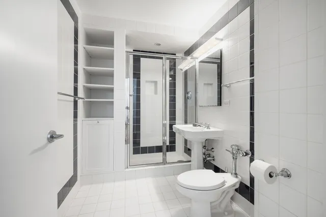 a bathroom with a tub sink shower and mirror