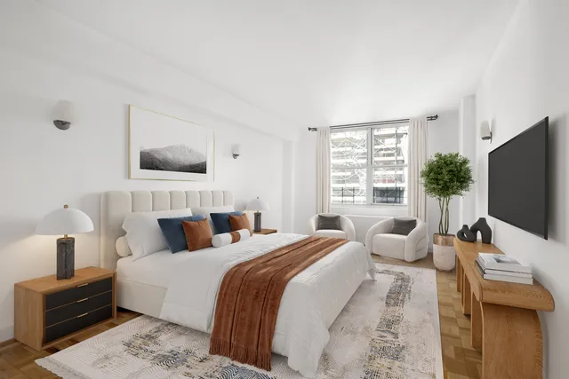 a bedroom with a bed a mirror and a large window