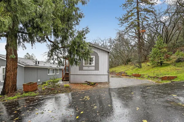 a view of a house with backyard and tree