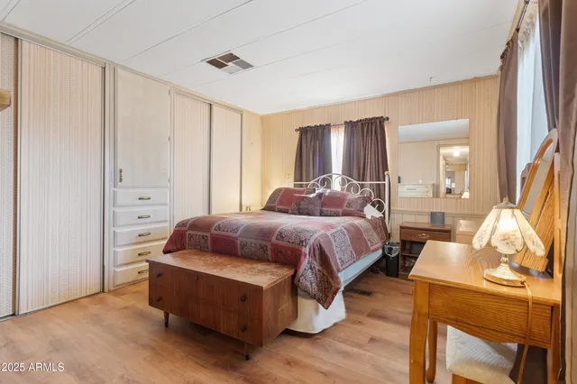 a bedroom with a bed and wooden floor