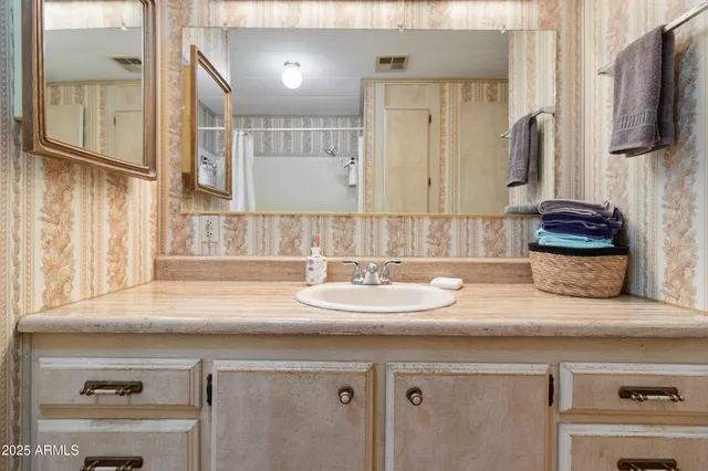 a bathroom with a sink double vanity granite and a mirror