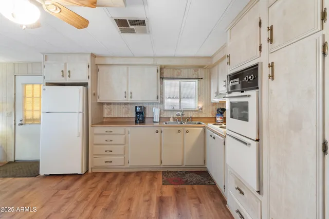a kitchen with white cabinets and white appliances