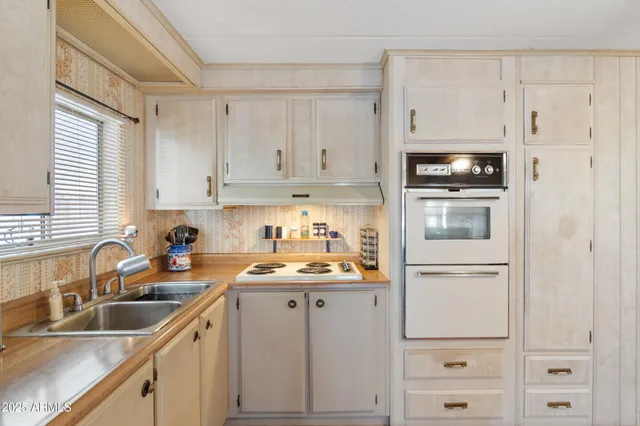 a kitchen with appliances a sink and cabinets