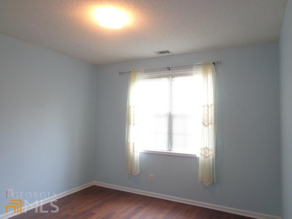 45 Chemin Place Sharpsburg, GA 30277 - Photo 14 of 26 an empty room with wooden floor and windows